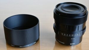 Объектив Sigma 65mm f/2 DG DN Contemporary рядом с цельнометаллической блендой LH656-01